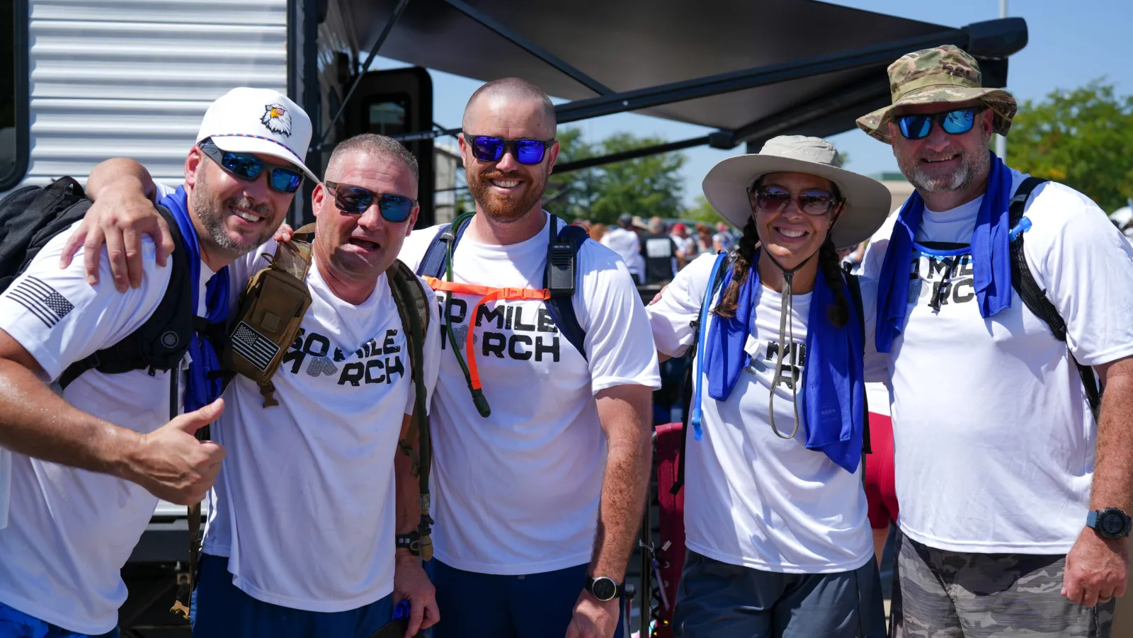 Werner associates in 50 Mile March shirts smiling together at the event.