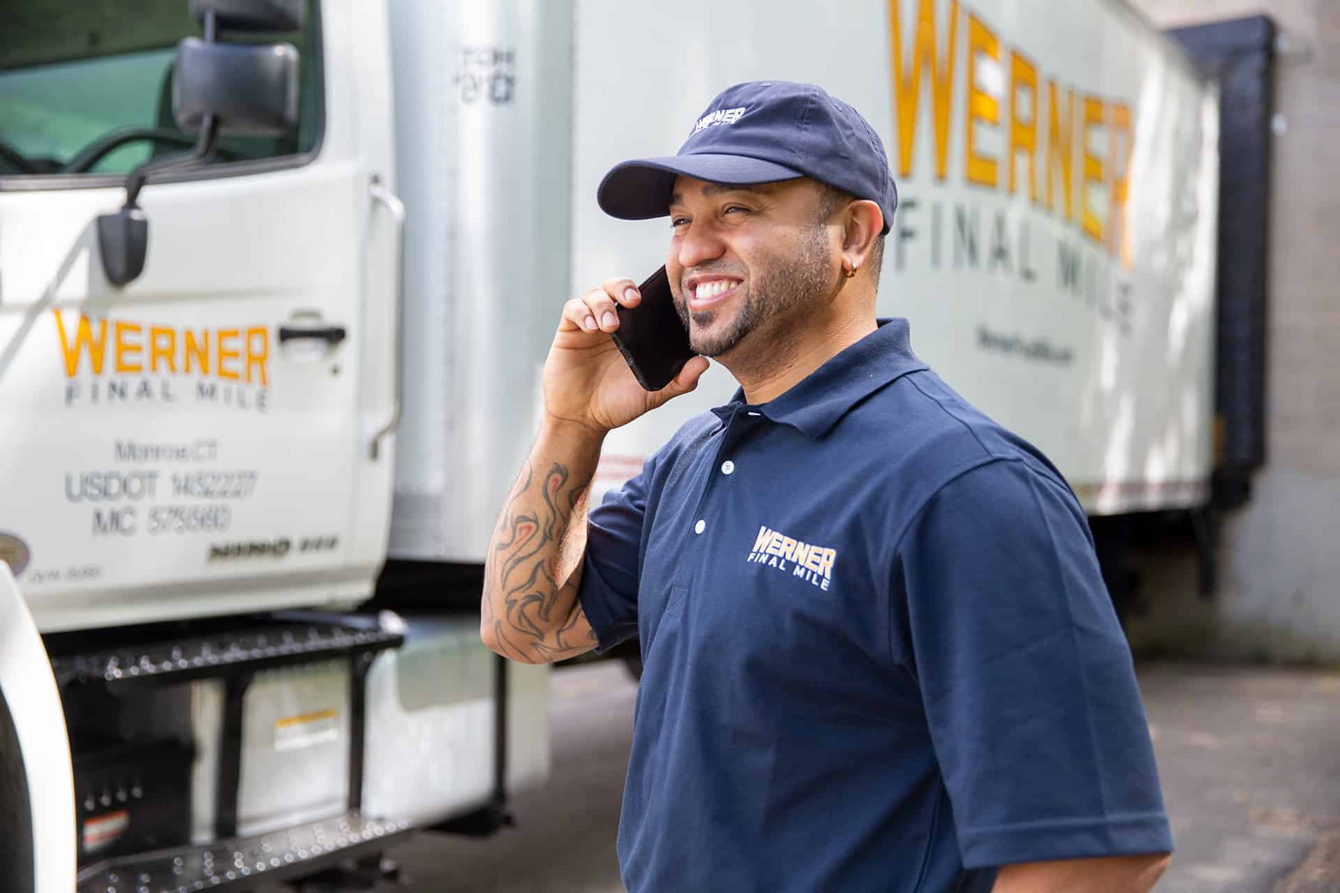 Werner Final Mile delivery driver on the phone beside his truck