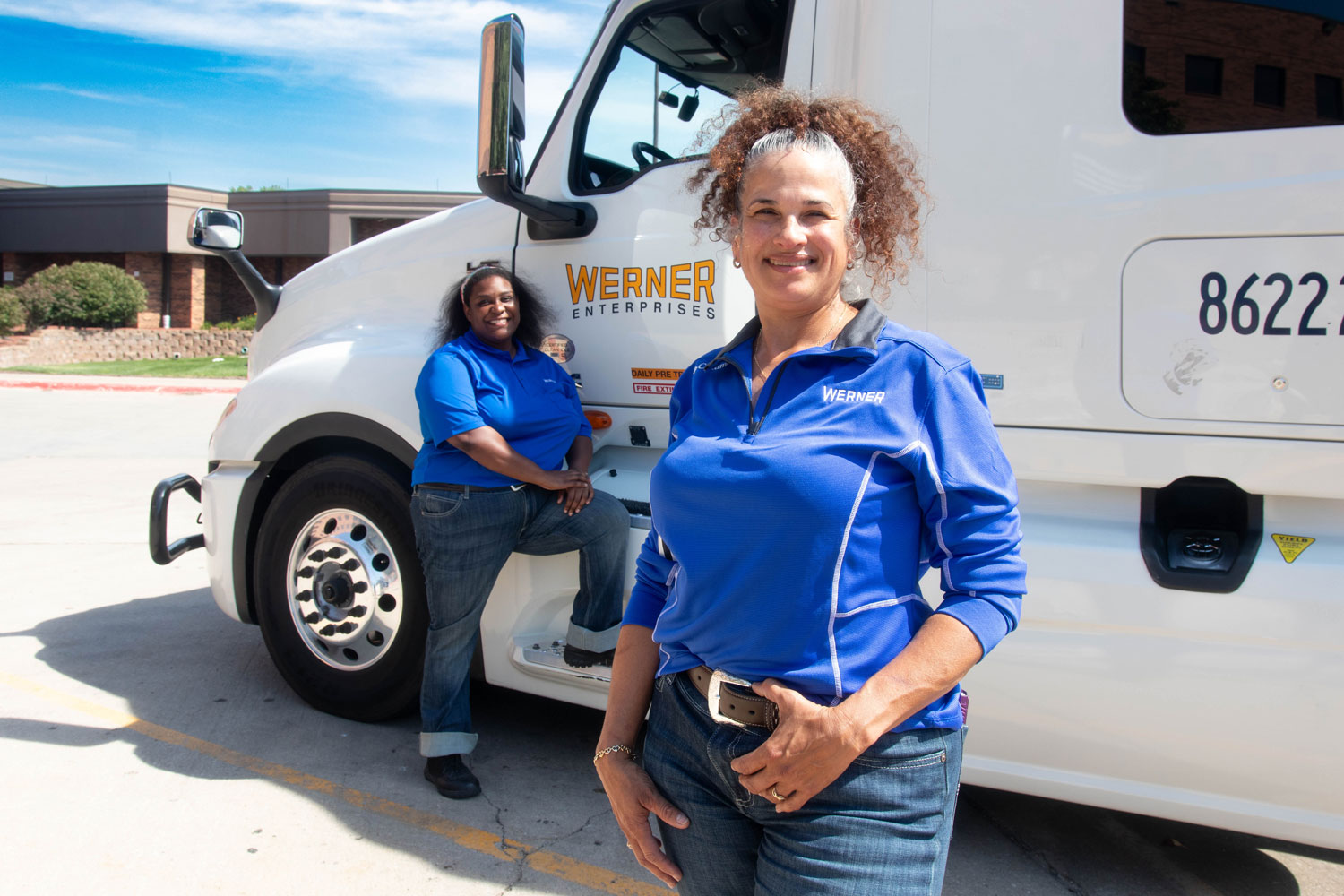 Brenda and Aisha, a Werner team driving pair, beside their truck