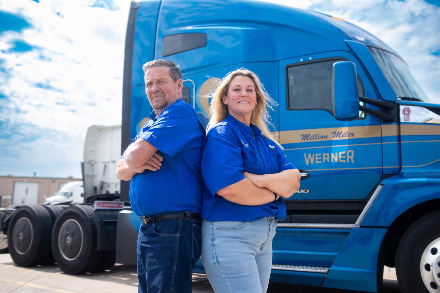 Two Werner team drivers standing together beside their truck